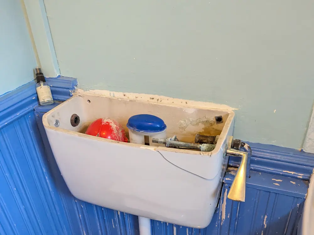 Old toilet cistern opened up with worn internals